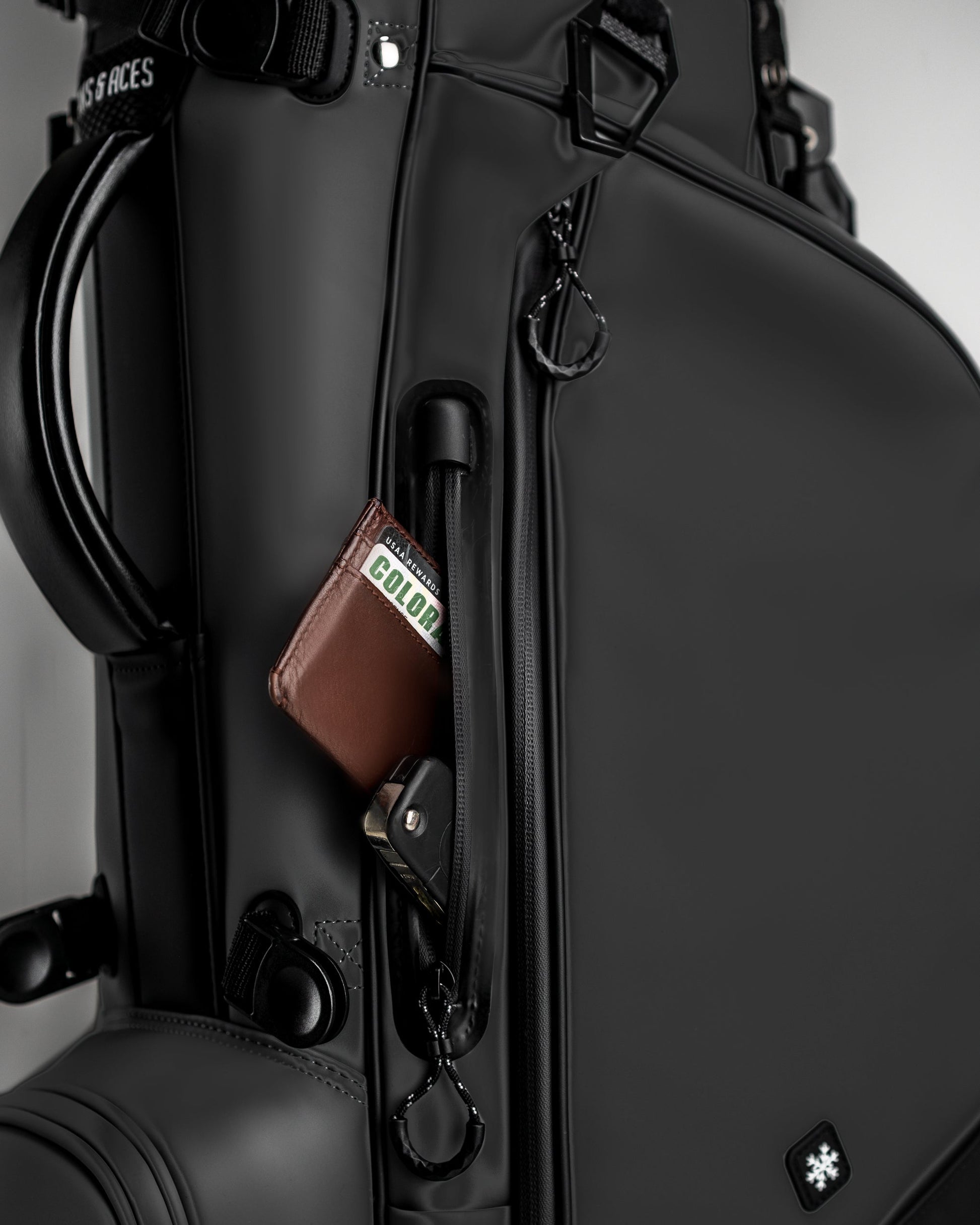 Sleek Player Preferred Golf Bag in Obsidian with a side pocket showcasing a wallet and keychain for convenient storage.