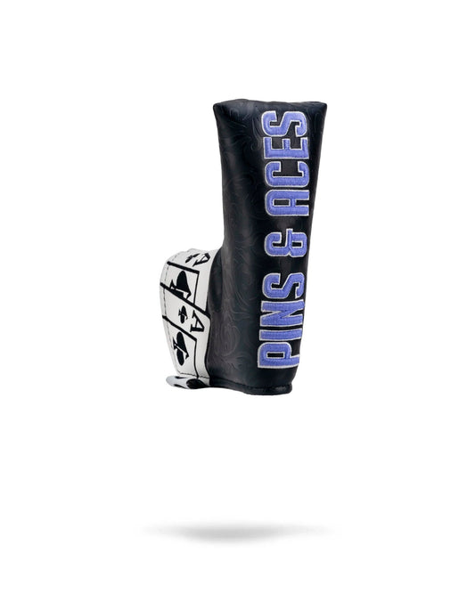 Alt text: "Black and white Ace of Spades blade putter cover featuring card suits design and large blue embroidered 'ACES & ACES' text, with a stylish patterned background."