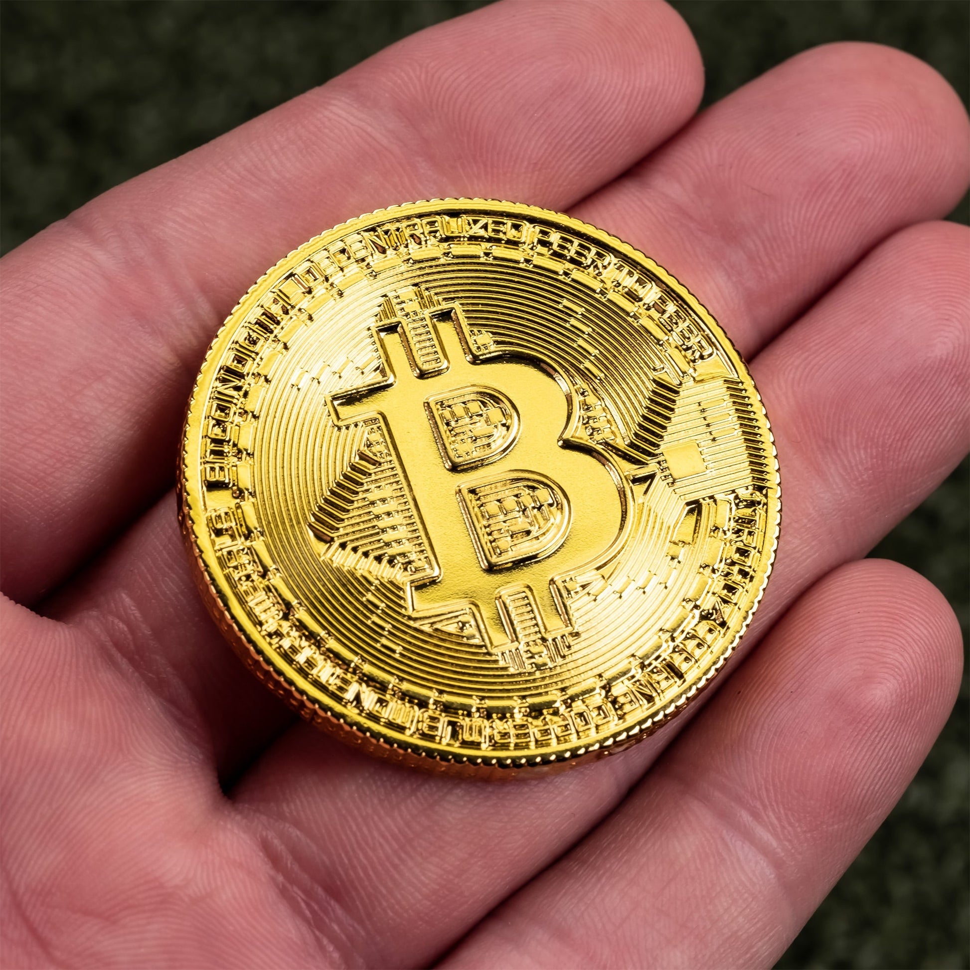 Bitcoin ball marker held in hand, featuring a gold Bitcoin design on a circular metal base.