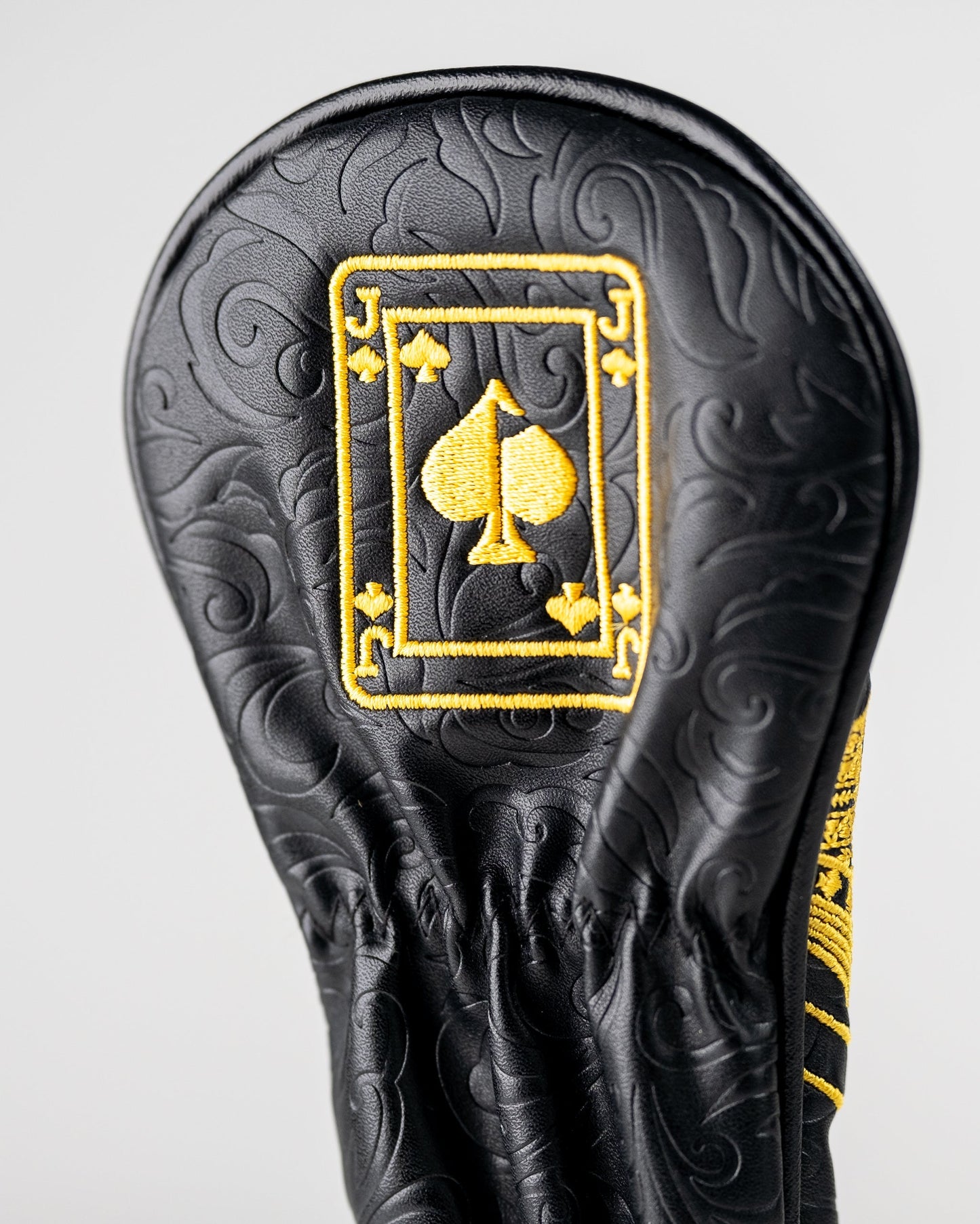Black and gold Jack of Spades hybrid golf club cover with intricate design.