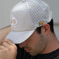 Perforated bone-colored rope hat with a stylish design, displayed in a lifestyle setting.