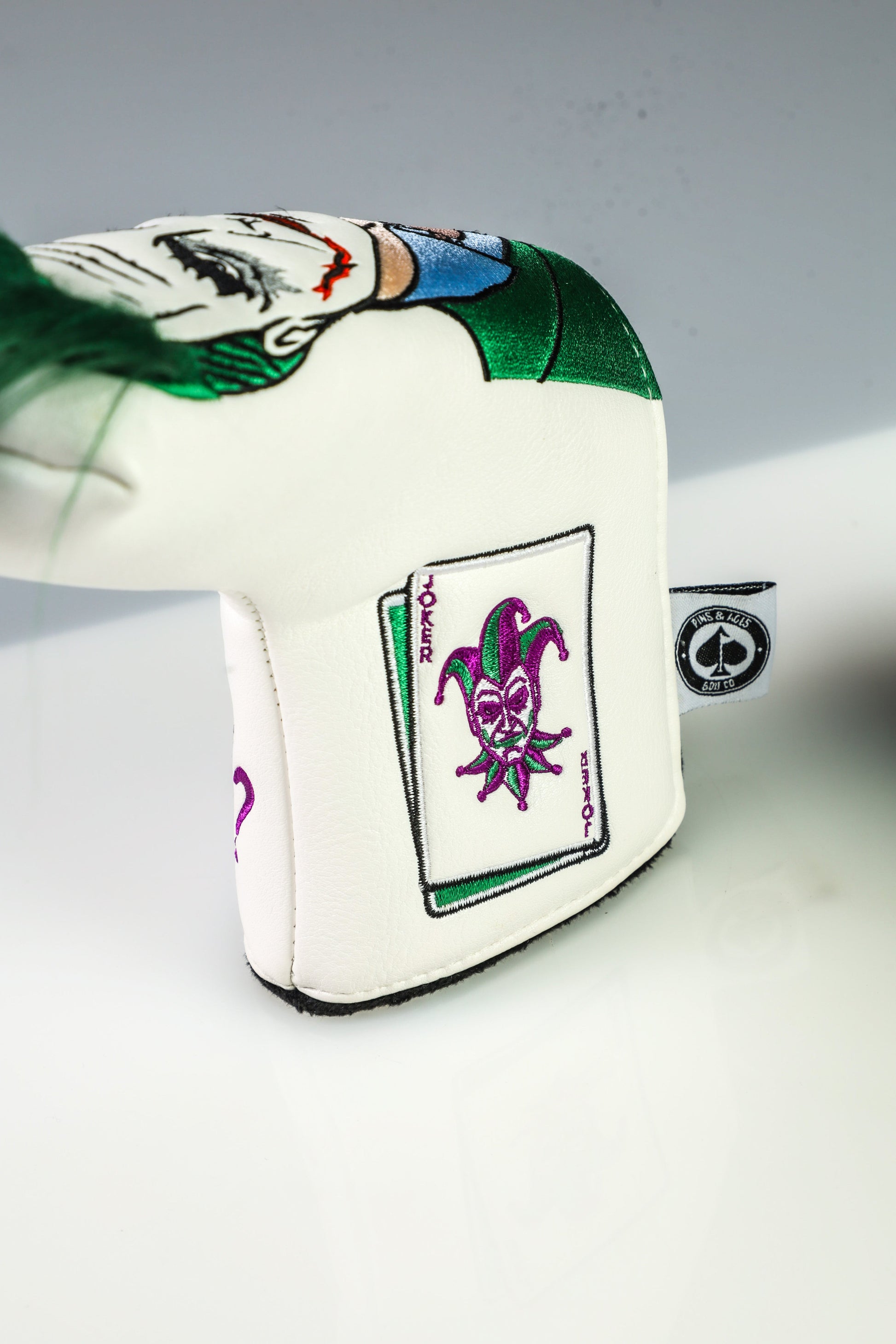 Joker-themed blade putter cover featuring vibrant colors and a playful design, perfect for golf enthusiasts.
