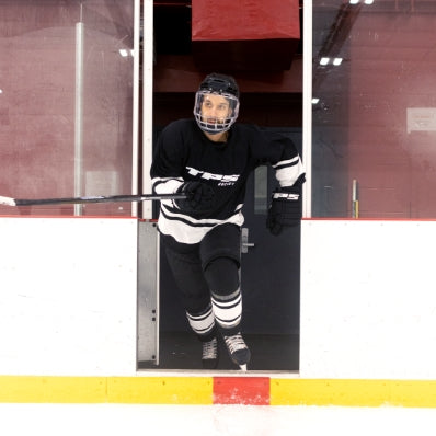 Person in hockey gear standing in a hockey rink