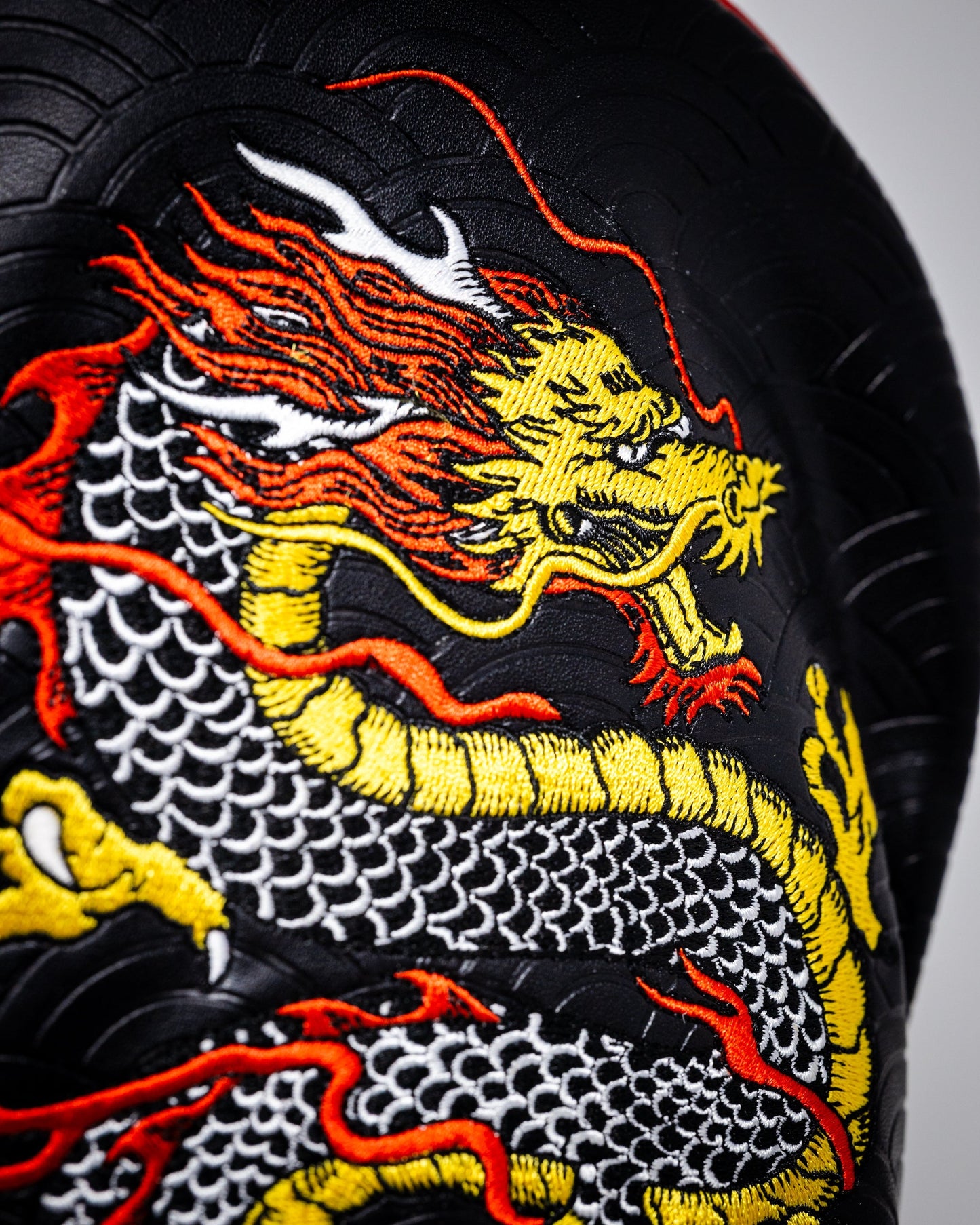 "Dragon's Dynasty Driver Cover featuring a vibrant dragon design on a black background."