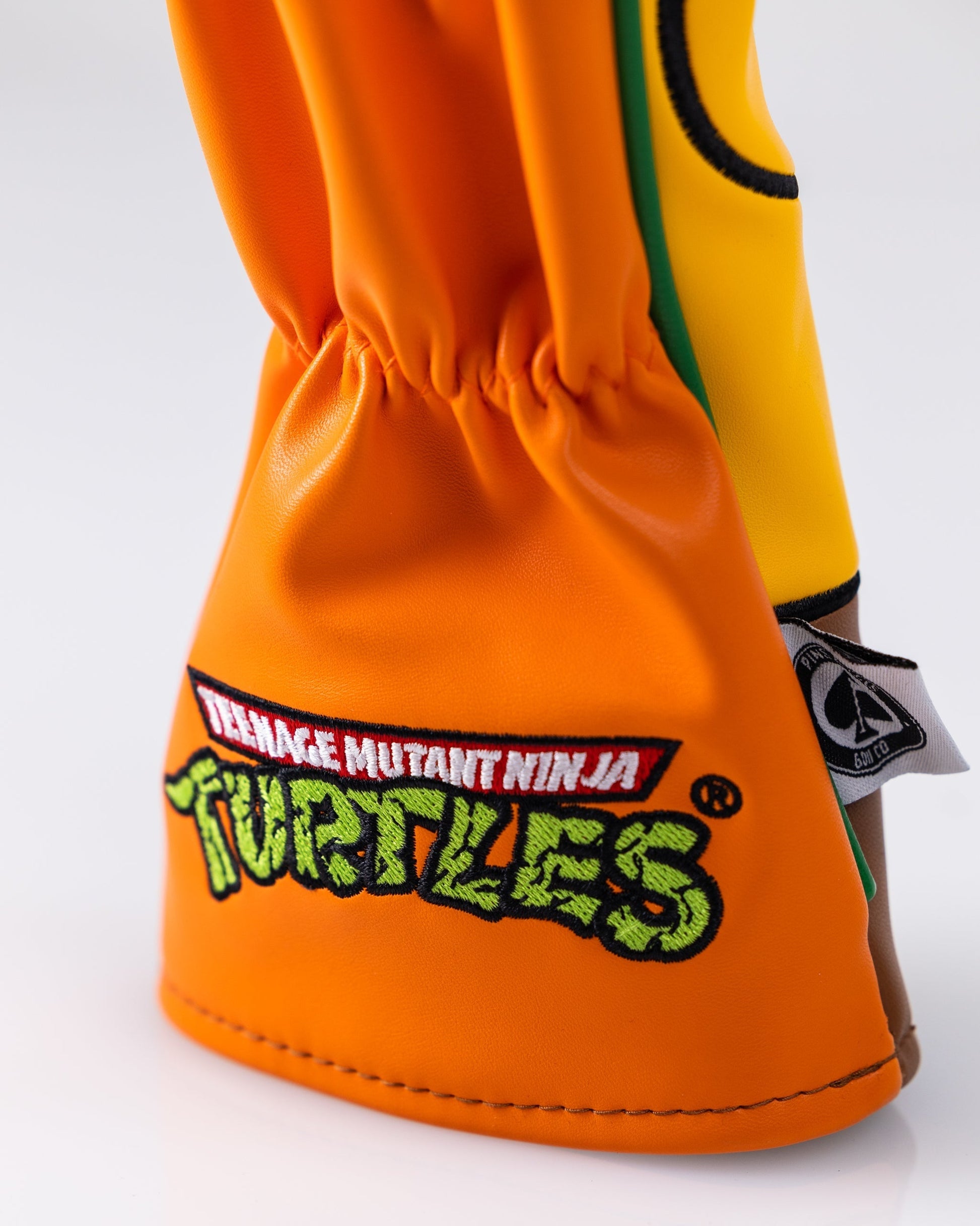 TMNT Michelangelo hybrid golf club cover featuring vibrant orange design and character details.