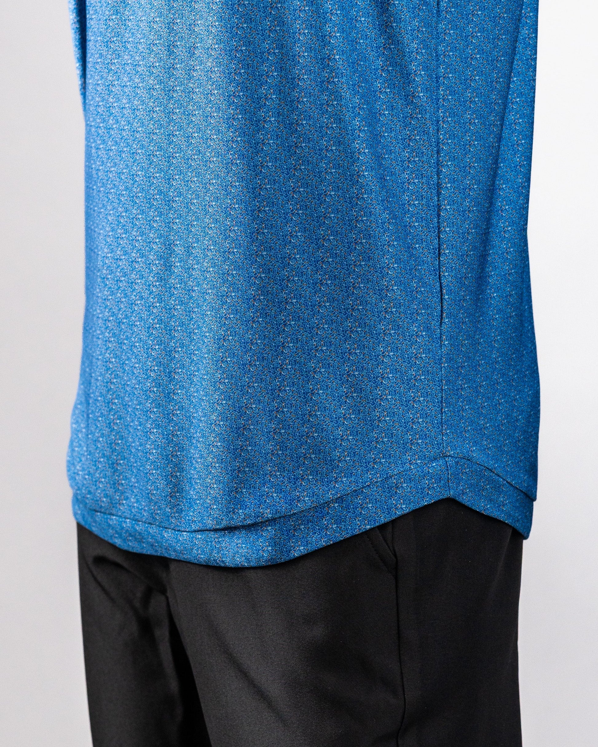 Close-up of a blue Player Preferred™ Polo shirt with a cosmic swirl pattern, paired with black pants.