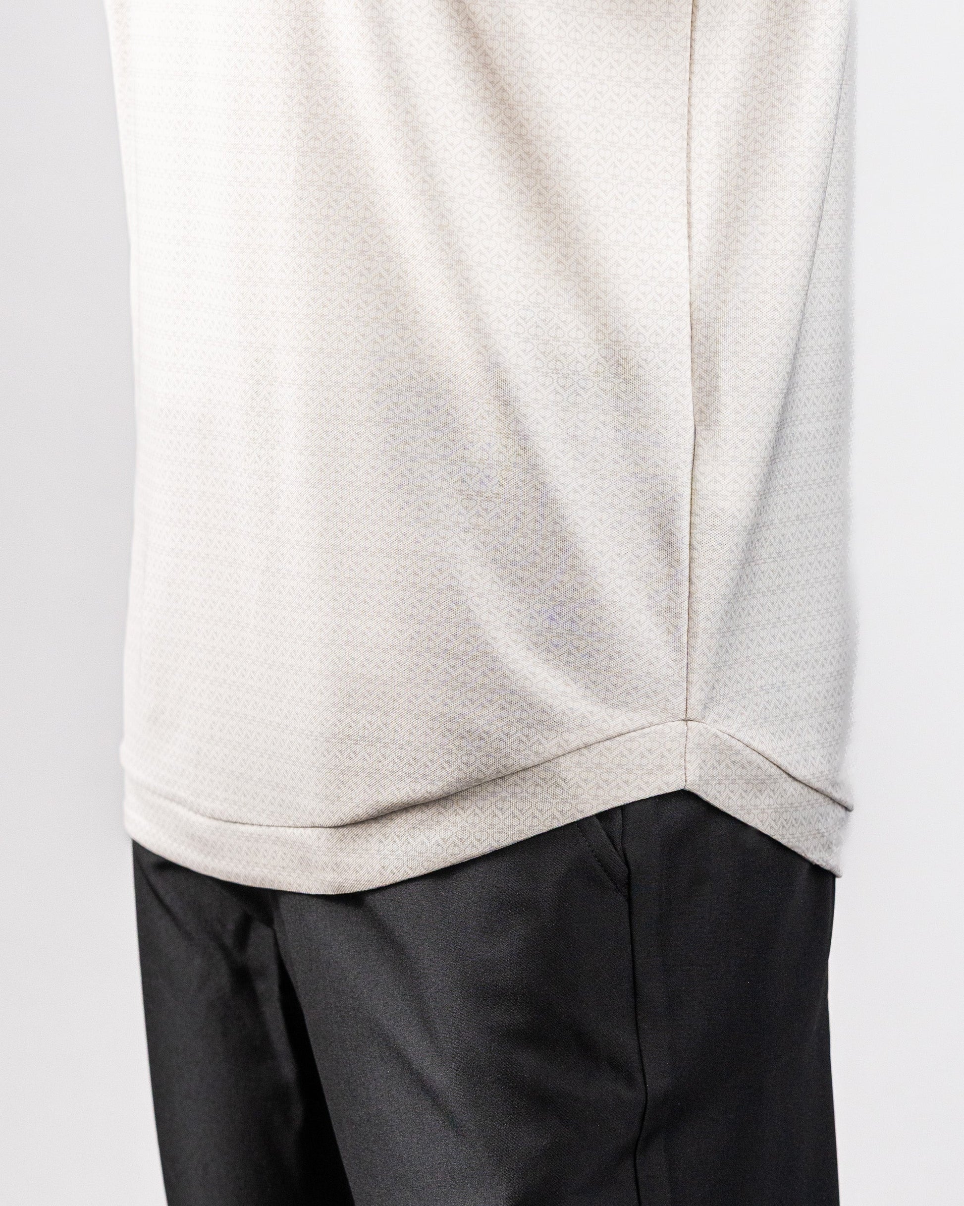 Close-up of a white Player Preferred™ Polo shirt with Vapor Spade pattern, paired with black pants.