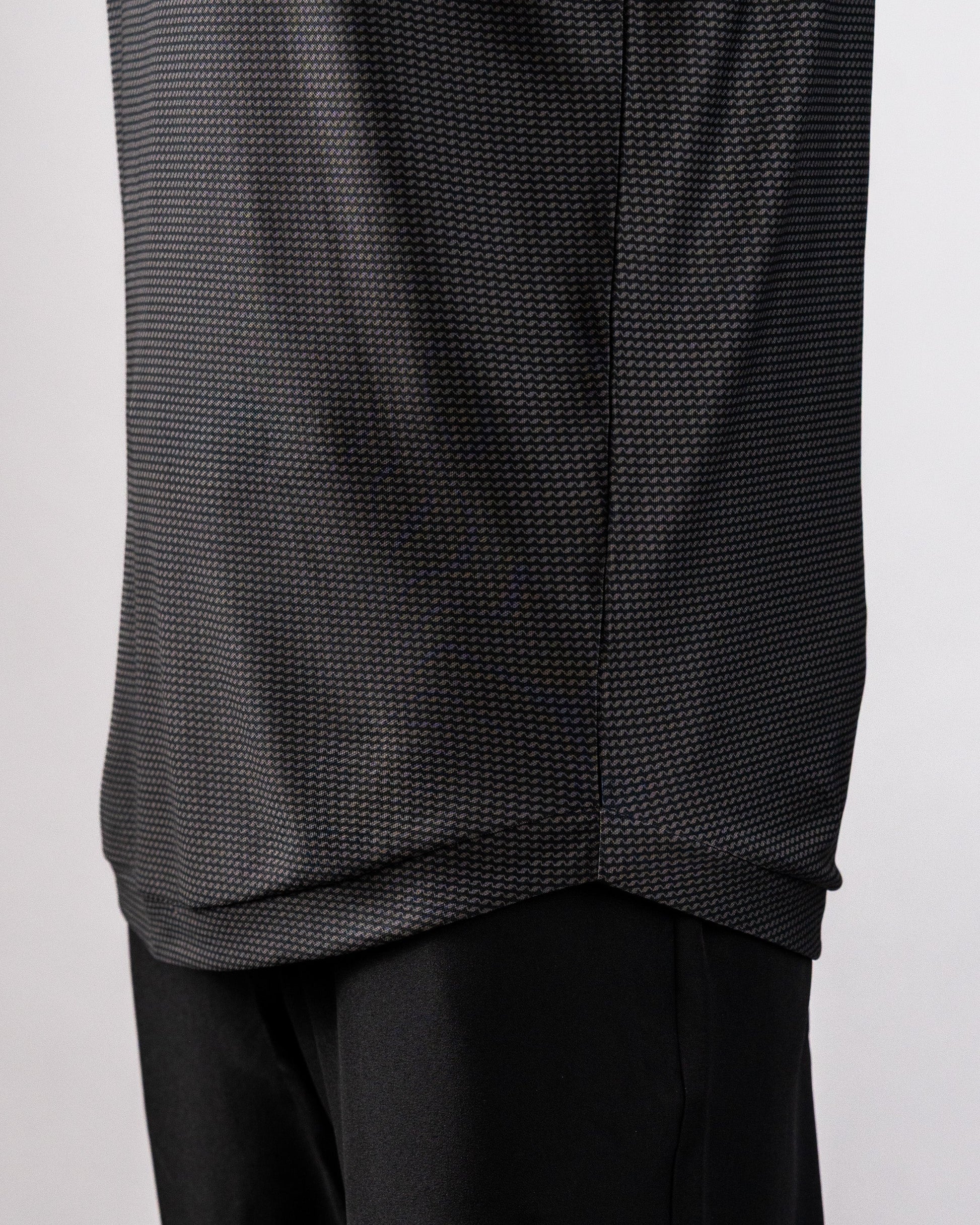 Close-up of a black Player Preferred™ Polo Night Wave with a subtle zigzag pattern, paired with black pants.