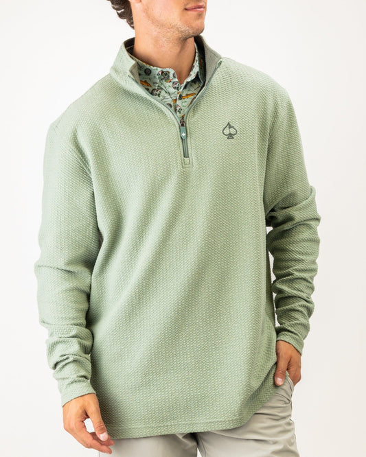 Olive green waffle knit pullover with a quarter zip and logo, perfect for stylish comfort on the golf course.