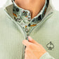 Olive waffle knit pullover with a half-zip collar, worn over a patterned shirt featuring golf-themed designs.