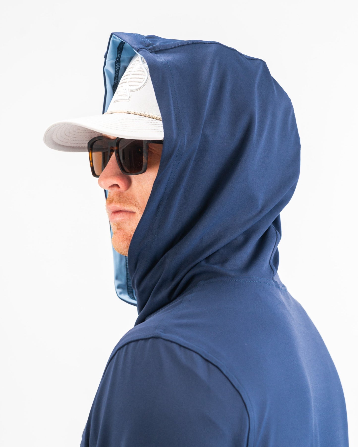 Navy performance golf hoodie featuring a fitted hood, worn by a man in sunglasses and a cap, ideal for stylish golfers.