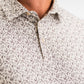 Close-up of the Player Preferred Polo featuring an old-fashioned print with golf-themed designs in neutral tones.