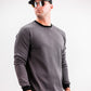 Male model wearing a slate grey Player Preferred™ Crewneck sweatshirt with black accents, black cap, and sunglasses, standing against a white background.