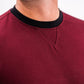 Close-up of a man wearing a maroon Player Preferred™ Crewneck with a black neckline detail, highlighting the fabric and stitching.