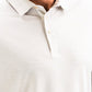 Close-up of a person wearing a white Player Preferred™ Polo - Vapor Spade with a subtle textured pattern and buttoned collar.
