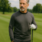 Man outdoors on golf course wearing a slate grey Player Preferred™ Crewneck sweater, holding a golf club, with trees in the background.