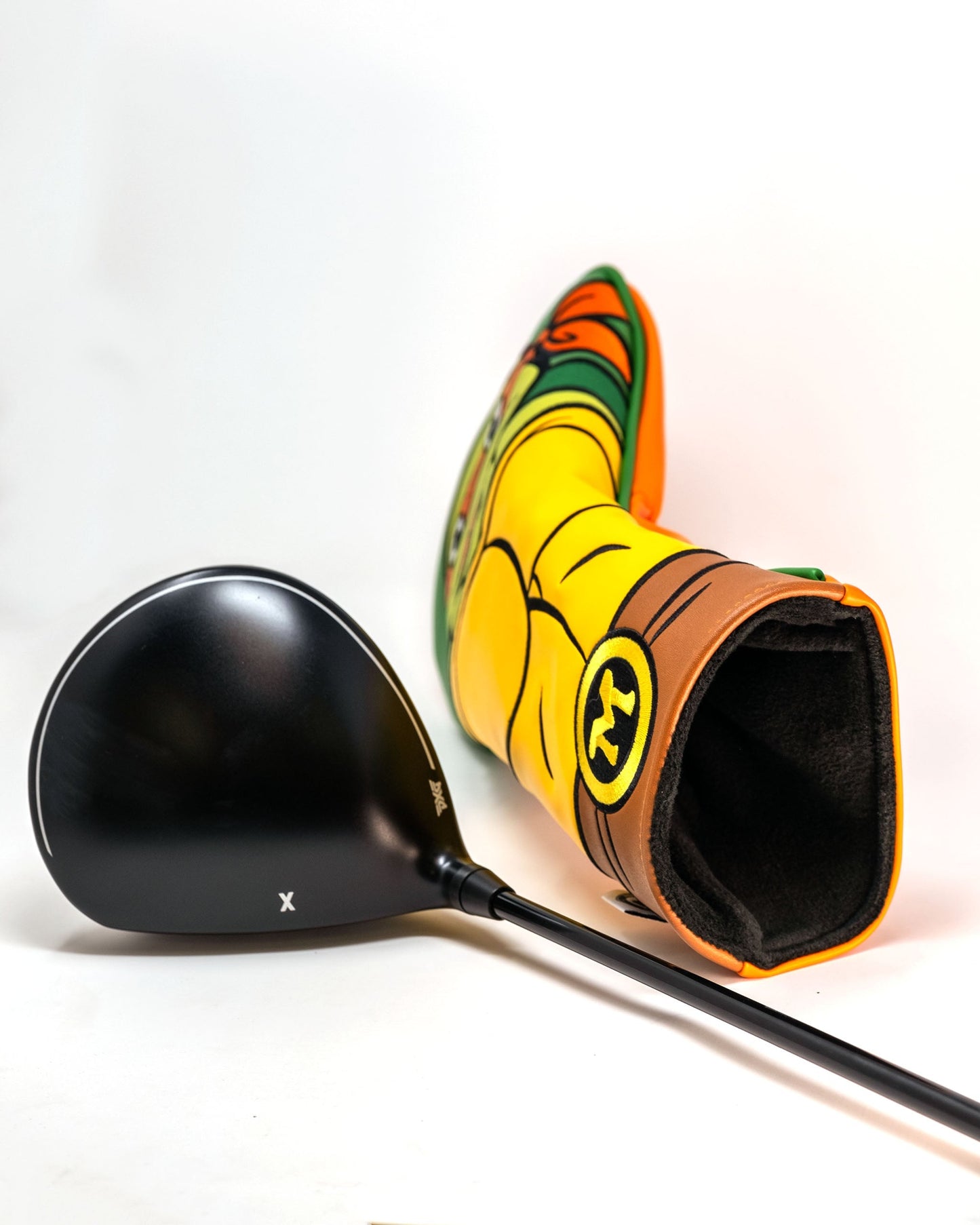 TMNT Michelangelo golf driver cover featuring vibrant orange color and a cartoon design of Michelangelo's face with his signature mask and toothy grin.