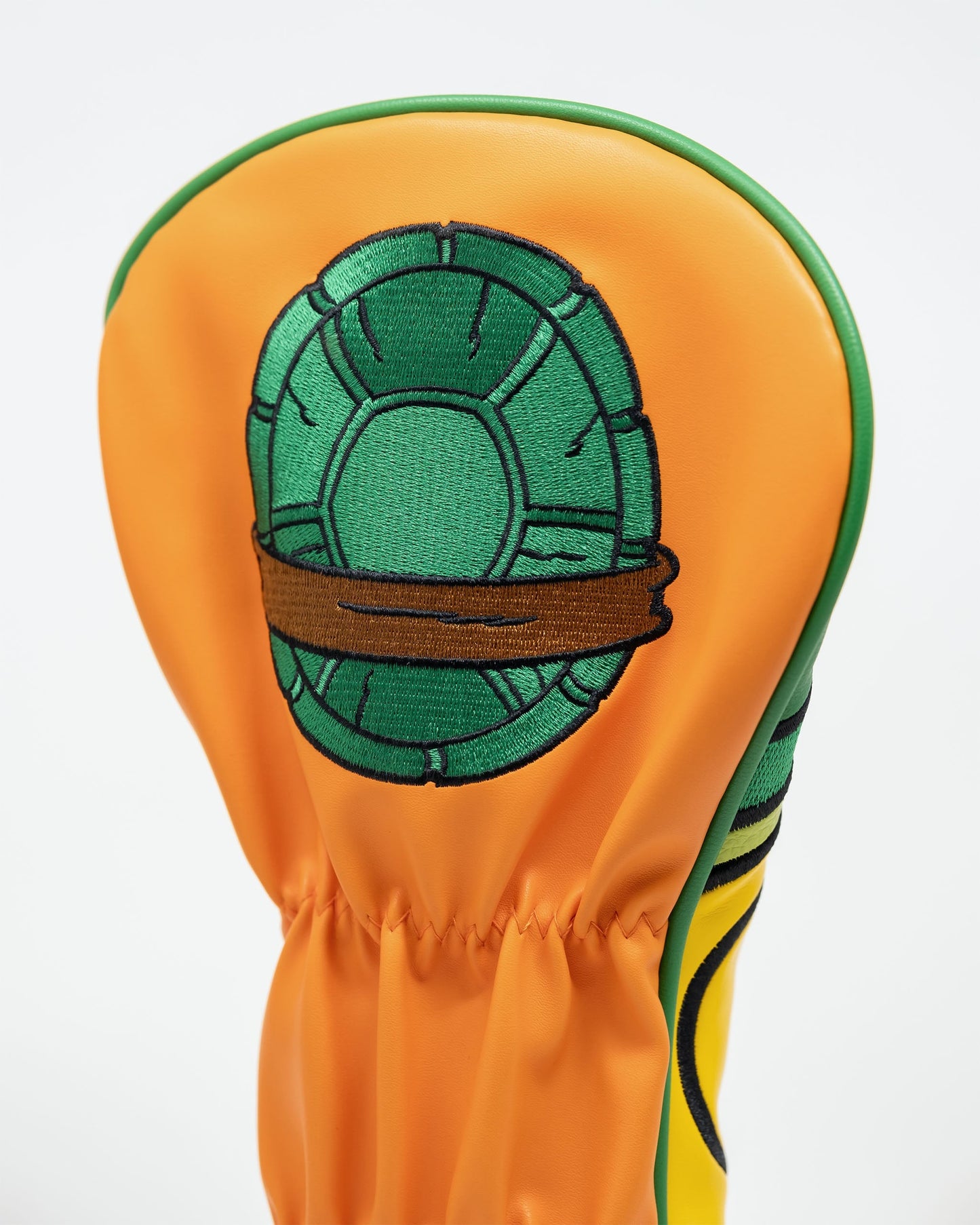 TMNT Michelangelo driver cover, featuring vibrant colors and a cartoon-style design of Michelangelo's face with his signature orange mask and nunchaku.