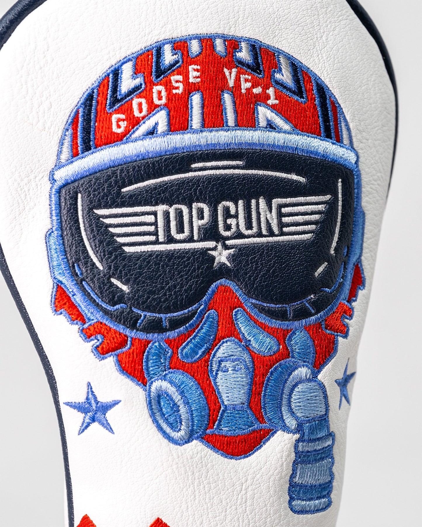 Embroidered Top Gun Goose hybrid headcover featuring a pilot helmet, sunglasses, and military-inspired design on white leather.