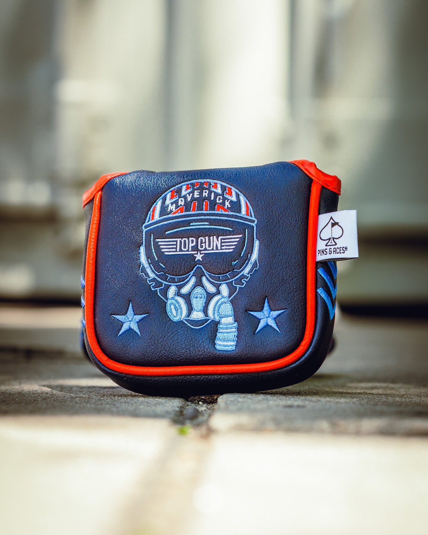 Top Gun themed golf mallet headcover featuring a skull with a helmet, goggles, and headphones design in blue, white, and red accents.