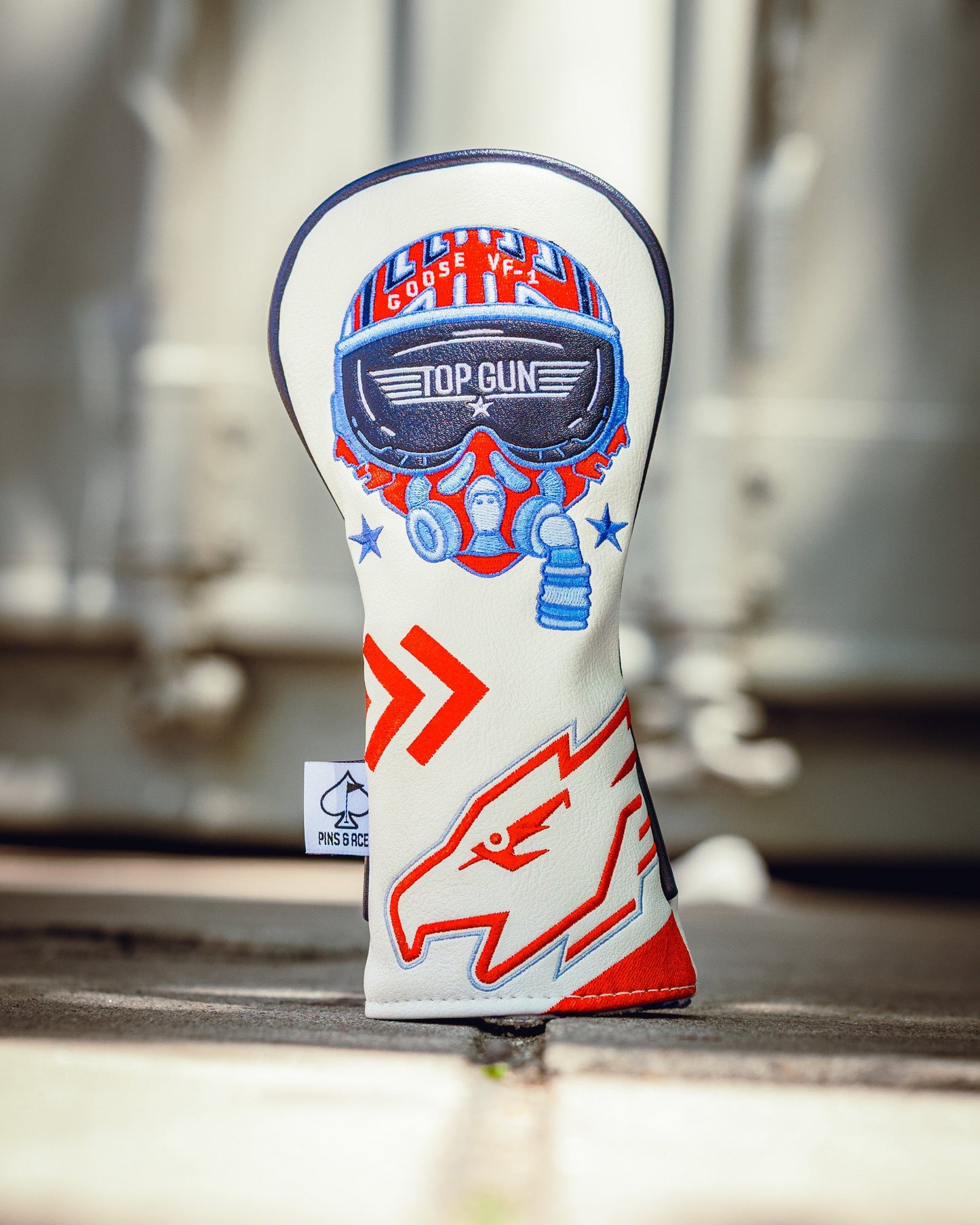 Golf club headcover featuring a Top Gun Goose design with aviation-themed patches and bold red, white, and blue colors.