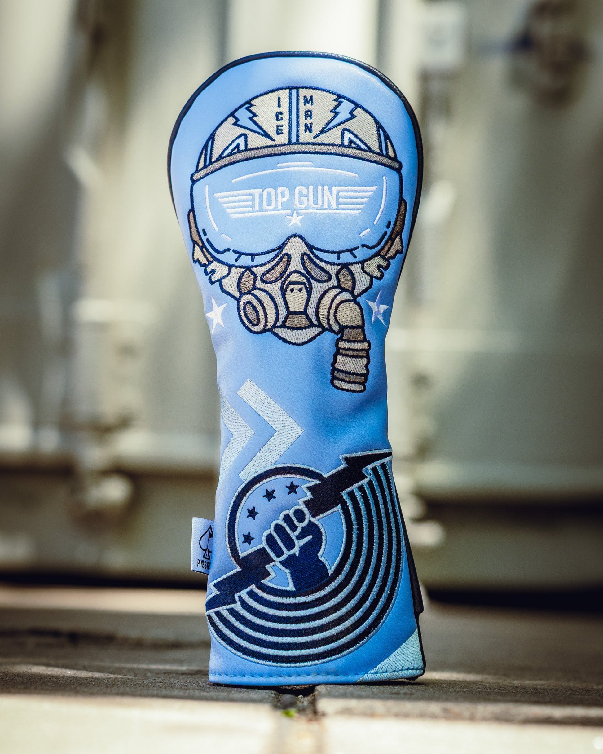 Top Gun Ice Man themed golf club headcover featuring a pilot helmet, goggles, and a clenched fist holding a lightning bolt.