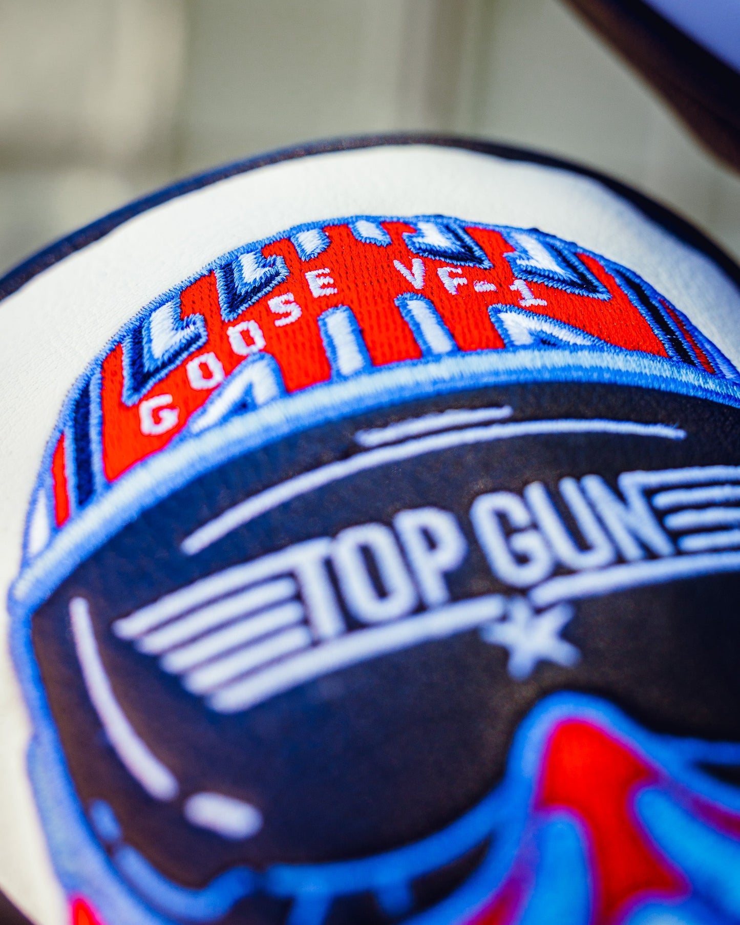 Close-up of a Top Gun Goose hybrid golf headcover with detailed embroidery in red, blue, and white colors.