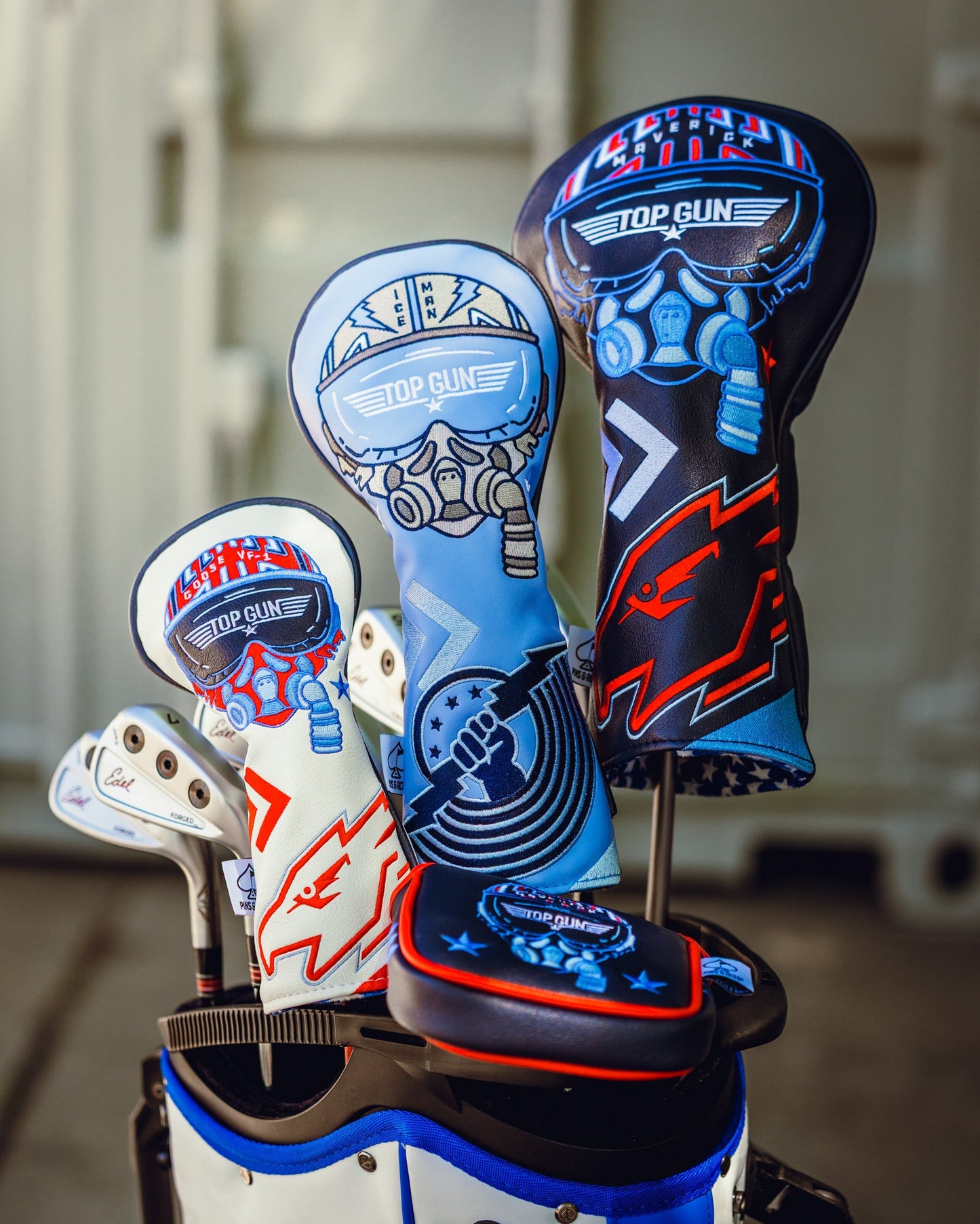 Set of Top Gun Maverick themed golf club headcovers featuring fighter pilot designs in blue, white, and black colors.