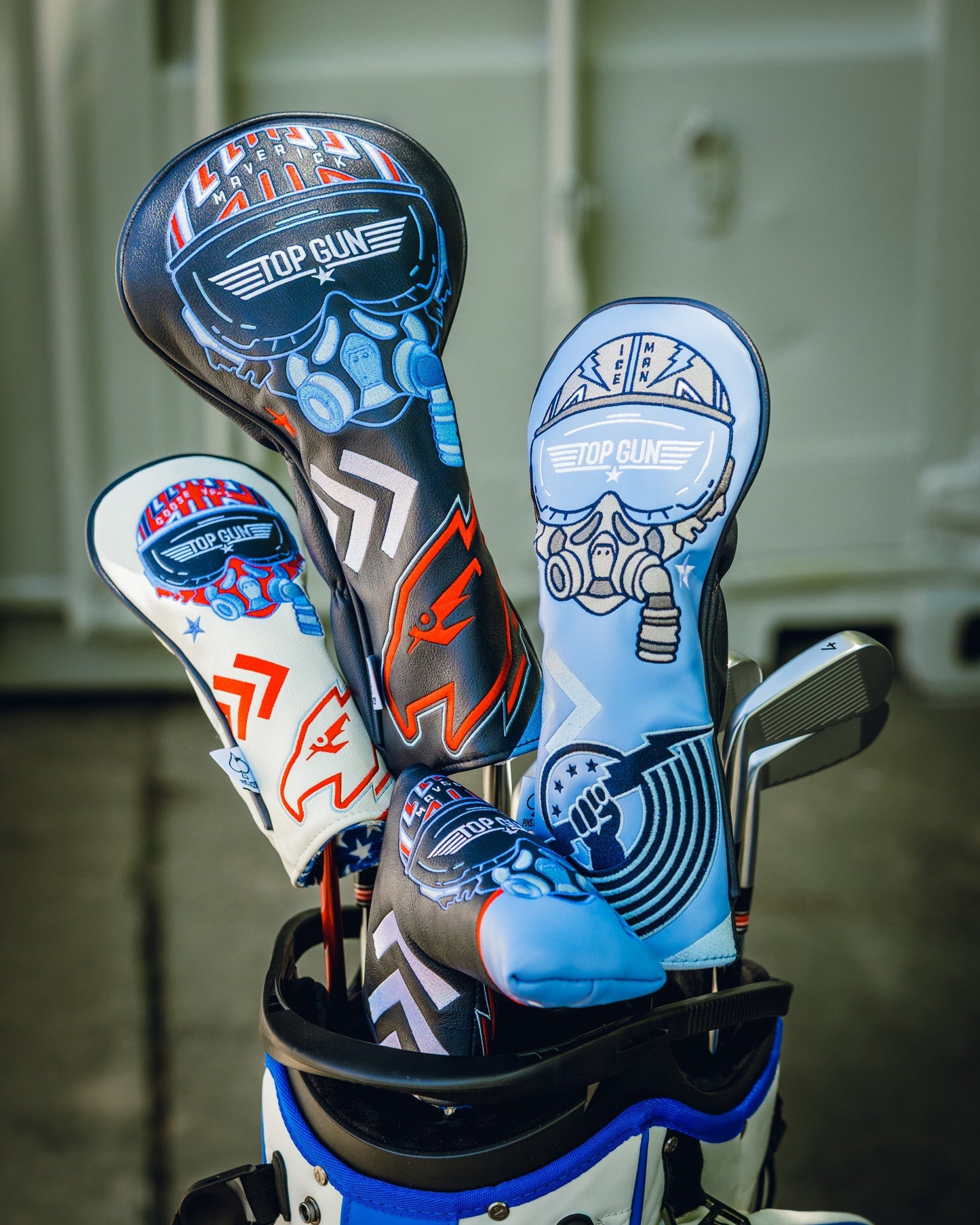 Set of three Top Gun Maverick themed golf club blade headcovers with skull and pilot helmet designs in black, white, and blue colors.