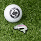 Trout ball marker featuring a detailed trout design, positioned beside a golf ball on a grassy surface.