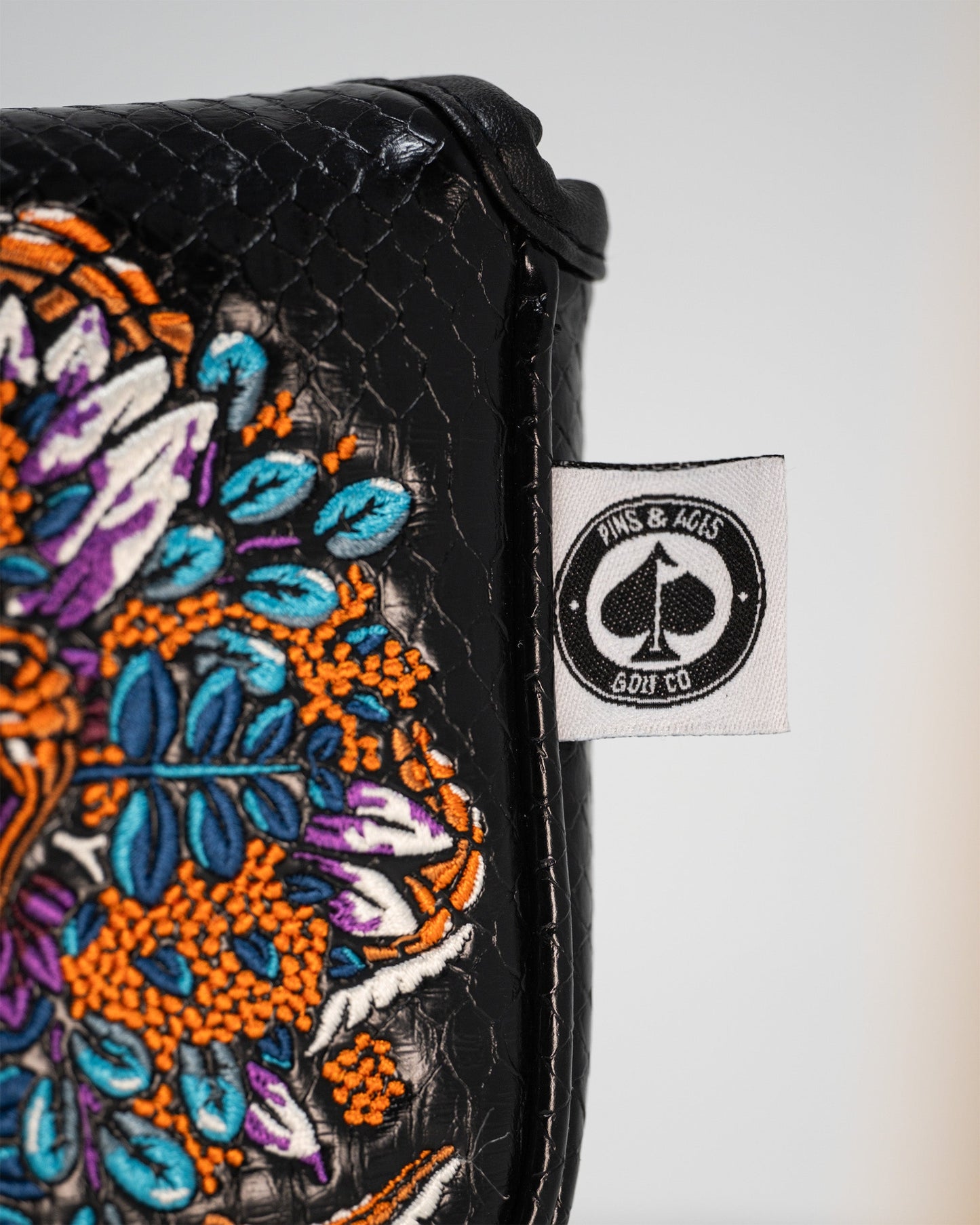 Alt text: Venom golf mallet putter cover with a black and red design featuring the Venom logo and spider motifs.