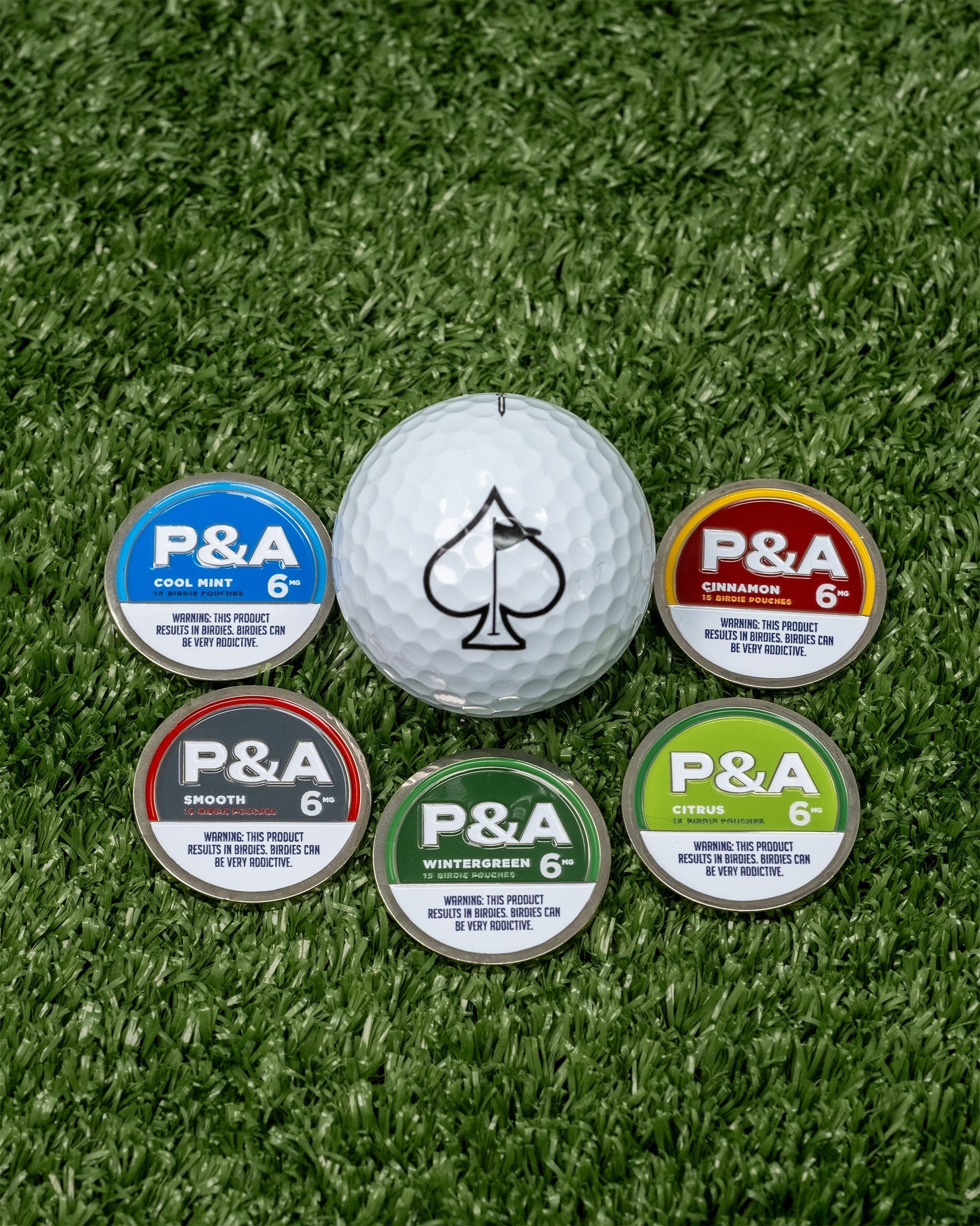 "6 Milly Cool Mint ball marker with four other flavors on green turf, featuring P&A branding.