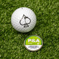 "6 Milly Citrus Ball Marker next to a golf ball with a spade logo, set on green turf.