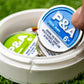 "6 Milly Cool Mint ball marker in a round container, showcasing vibrant packaging on green grass.