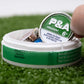 "6 Milly Spearmint ball marker being removed from a container on green turf.